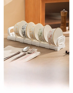 Detail of floral underglaze ceramic bowls set with a gold rim and plastic storage rack