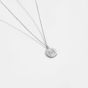 Macro detail of S925 sterling silver round pendant with letter M in colorful zircons