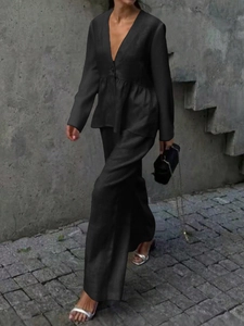 Detail of elegant black satin long sleeve top and wide-leg trousers set with silk finish