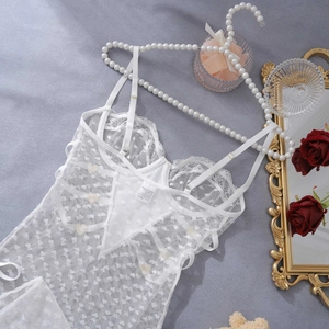 Close-up of white lace lingerie bodysuit with heart patterns and adjustable straps