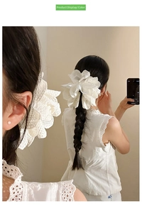 Detailed view of a white lace flower hair claw with pearls worn on a braided ponytail