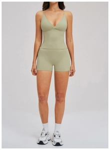 Detail of high-stretch sage green yoga set showing cross-back vest and high-waist shorts