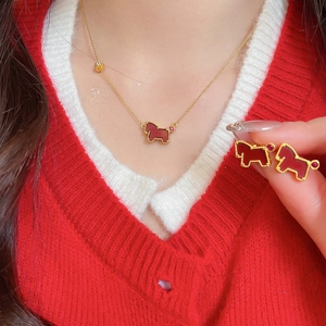 Model wearing gold necklace and holding red horse earrings set with zircon details