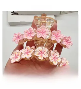 Detailed view of pink floral hair claw clip with frosted cherry blossom petals and spring