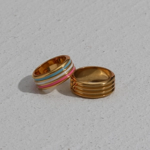 Close-up of gold stainless steel rings with colorful enamel drip oil and textured layers