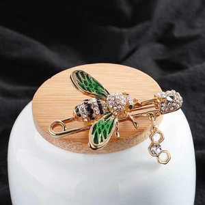 Exquisite gold bee brooch with green enamel wings, sparkling rhinestones and honeycomb charm