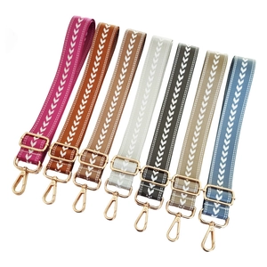 Adjustable woven nylon shoulder straps with chevron patterns and gold swivel hooks