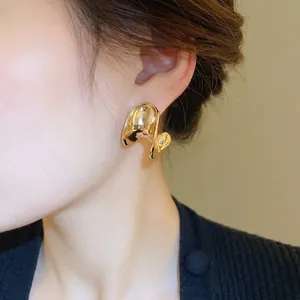 Minimalist C-shaped gold plated stud earrings with a glossy irregular curved design