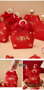 Detail of red hexagonal wedding gift box with wooden ring handle and gold foil printing
