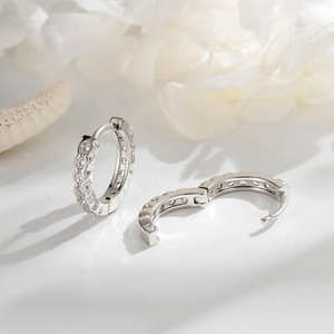 Minimalist silver earrings with cubic zirconia set on soft white petals and shells