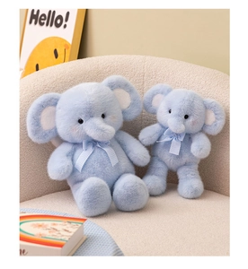 Close-up of sky blue plush elephant dolls with checkered bows on a cozy beige sofa