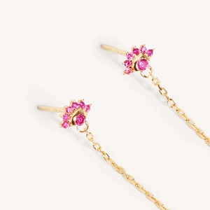 Orecchini a fiore con gemme rosa e nappe a catena dorata su sfondo bianco puro