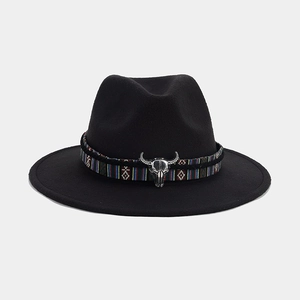Détail du chapeau fedora noir avec ruban ethnique et emblème de crâne de taureau argenté