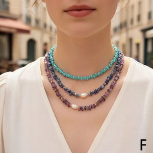 Close-up of layered necklace with colorful crushed stones and white pearls on model