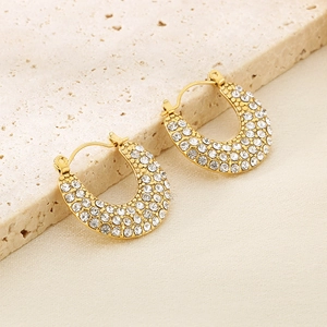 Gros plan détaillé des boucles d'oreilles en U dorées avec pavé de strass étincelants