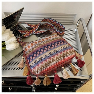 Detail of colorful woven bohemian bag with zigzag patterns and vibrant tassels