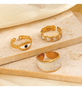 Detailansicht goldener Boho-Ringe mit bösem Blick und weißem Emaille-Herz-Anhänger