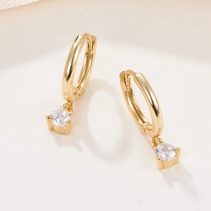 Detail of gold-plated hoop earrings featuring clear round cubic zirconia pendant drops