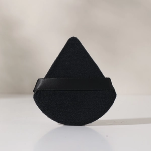 Detalle de la borla triangular negra de algodón con cinta de satén para fijar