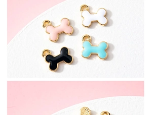 Macro view of colorful enamel dog bone charms in white, pink, black and blue colors