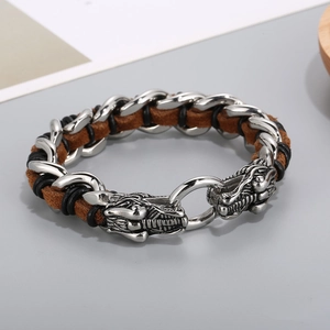 Detalle del cierre de cabeza de dragón en pulsera de cuero trenzado marrón y negro