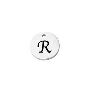 Macro view of mirror polished stainless steel round charm with engraved letter R