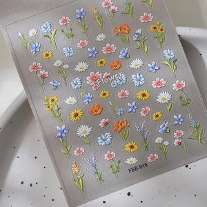 Detailed macro view of 3D embossed floral nail stickers featuring sun flowers and daisies