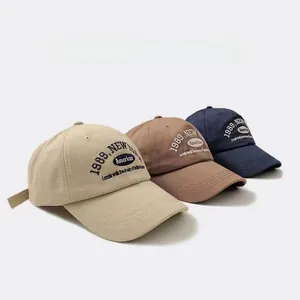 Detailed view of three vintage 1989 baseball caps in khaki, brown and navy blue colors