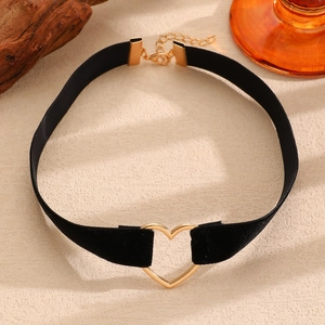 Dettaglio del choker in velluto nero con anello a cuore dorato e catena regolabile