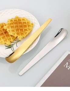 Nahaufnahme von Gold- und Silber-Edelstahllöffeln für Joghurt, Eiscreme und Desserts