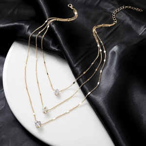 Three-layer gold layered necklace featuring star and heart crystal pendants on silk