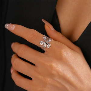 Detail of silver textured flower open ring featuring intricate petal carvings on finger