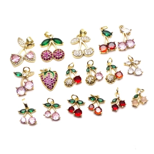 Set of 17 gold fruit charms featuring cherry and strawberry pendants with zircon inlays