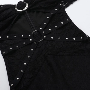 Dettaglio macro in pizzo nero con anelli di metallo argento e borchie decorative