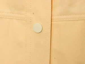 Détail du tissu en sergé de coton orange montrant des boutons ronds et la double couture