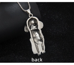 Macro detail of the matte vintage silver dog pendant back view on a beaded chain