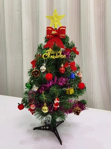 Mini Christmas tree with red bows, gold stars, pine cones and festive ornaments