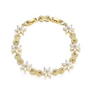 Dettaglio del bracciale dorato con fiori, pietre di zircone e maglie a infinito