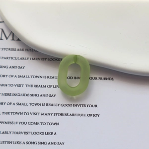 Gros plan sur un maillon ovale en acrylique vert clair mat translucide pour bijoux DIY