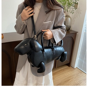 Detail of a black dachshund dog-shaped handbag with adjustable crossbody shoulder strap