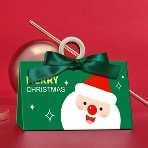 Green Christmas gift box with dark green ribbon and wooden ring on red background