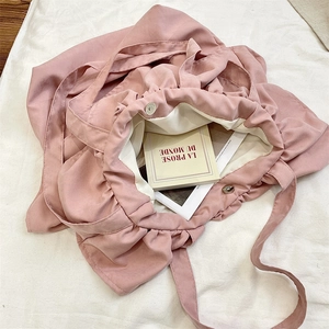 Detail view of pink ruffled tote bag with magnetic closure and soft fabric interior