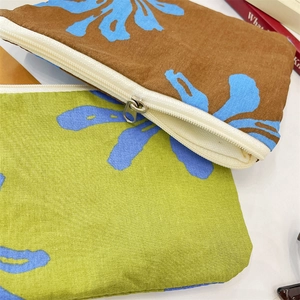 Close-up of floral cotton pouches with cream zippers for makeup and small accessories