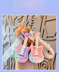 Close-up of guitar keychain with Rock and Roll wrist strap in vibrant colors