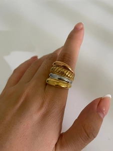 Close-up of layered 18K gold and silver rings featuring polished and twisted rope textures