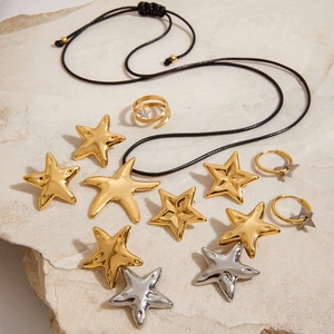 Flat lay of starfish jewelry set including gold rings, earrings, and a woven necklace