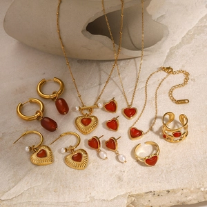 Detail of 18k gold-plated stainless steel jewelry set with red hearts and pearls