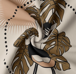 Macro detail of bohemian tapestry fabric showing monstera leaf prints and soft texture
