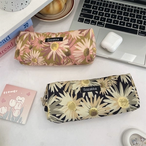 Detailed view of floral canvas pencil cases with daisy patterns on a cozy student desktop