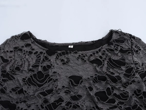 Détail de l'encolure d'un pull gris usé avec étiquette de taille S et doublure noire